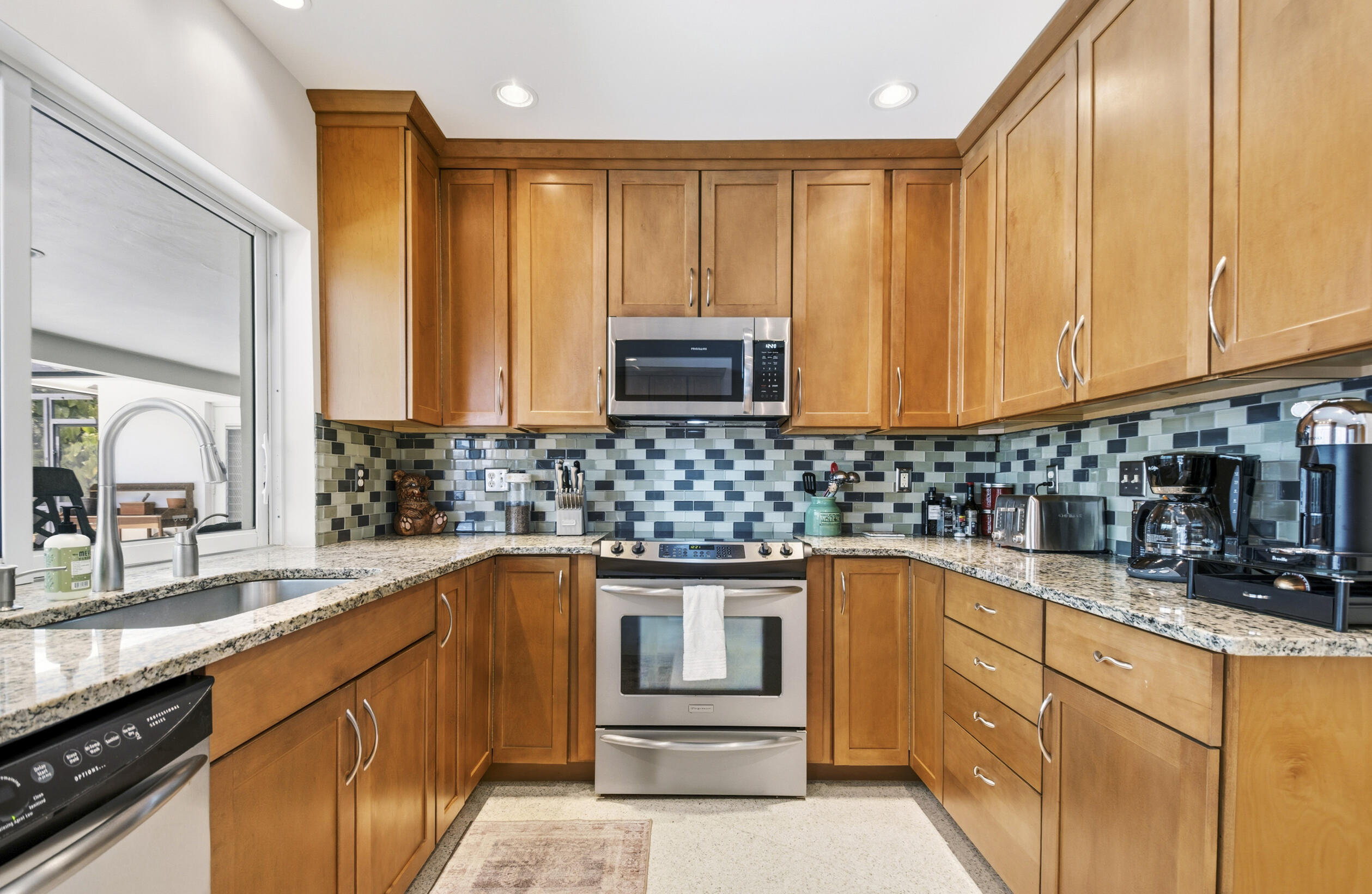 1348 Southwest 4th Street Boca Raton, FL 33486 - Photo 10 of 44 a kitchen with granite countertop a sink and cabinets