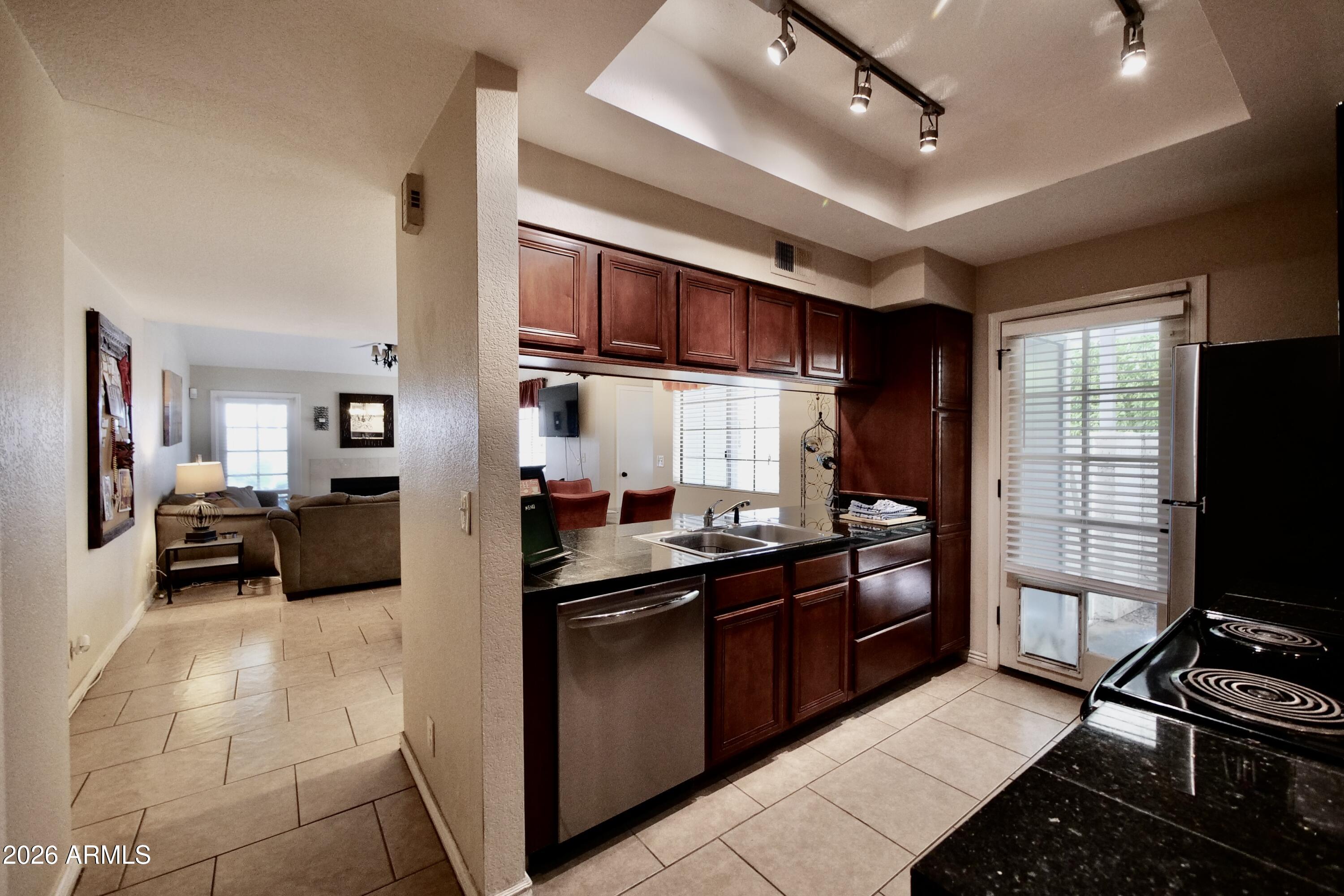 1222 West Baseline Road, Unit 156 Tempe, AZ 85283 - Photo 11 of 27 a kitchen with stainless steel appliances kitchen island granite countertop a sink and cabinets