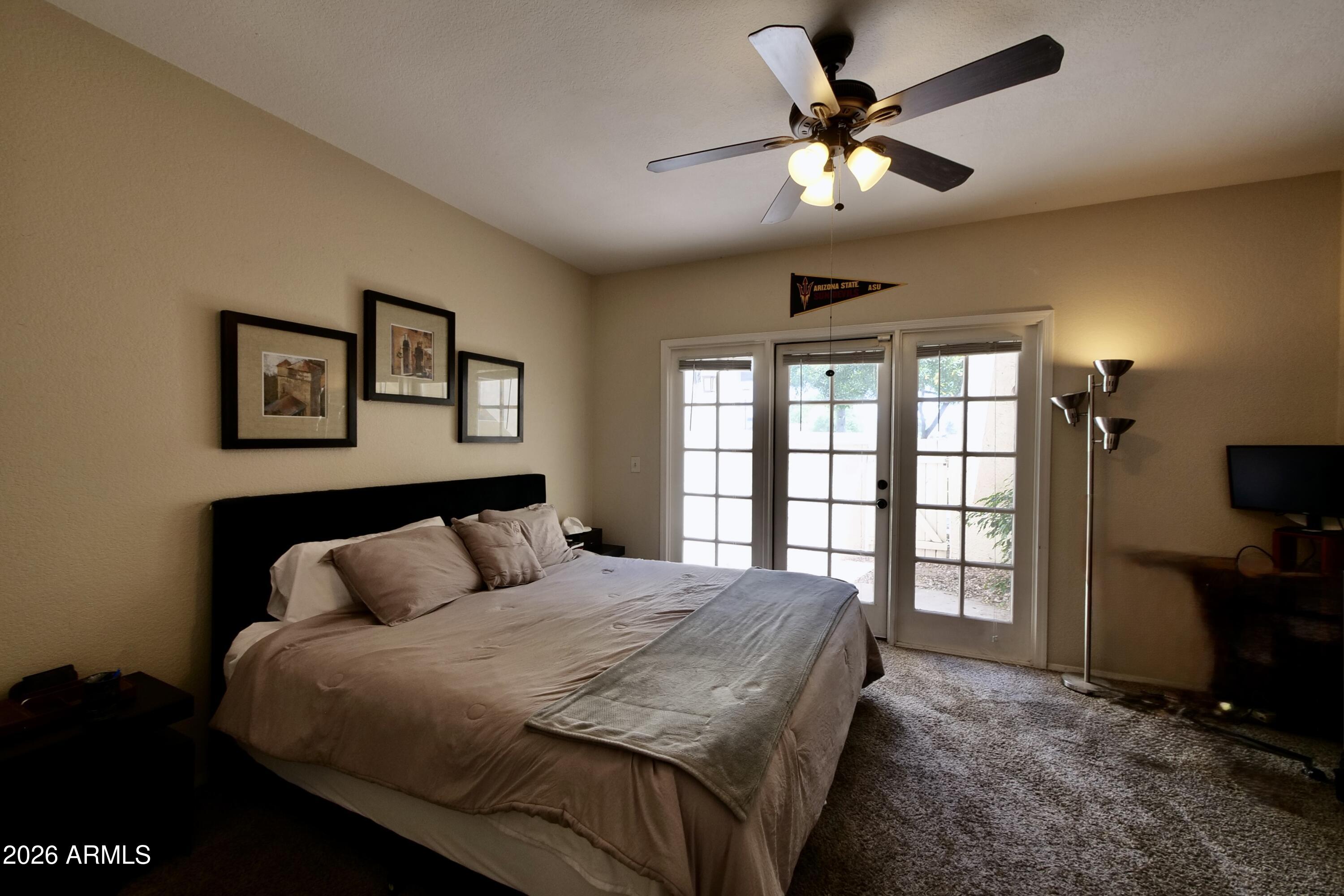 1222 West Baseline Road, Unit 156 Tempe, AZ 85283 - Photo 15 of 27 a bedroom with a large bed and a chandelier