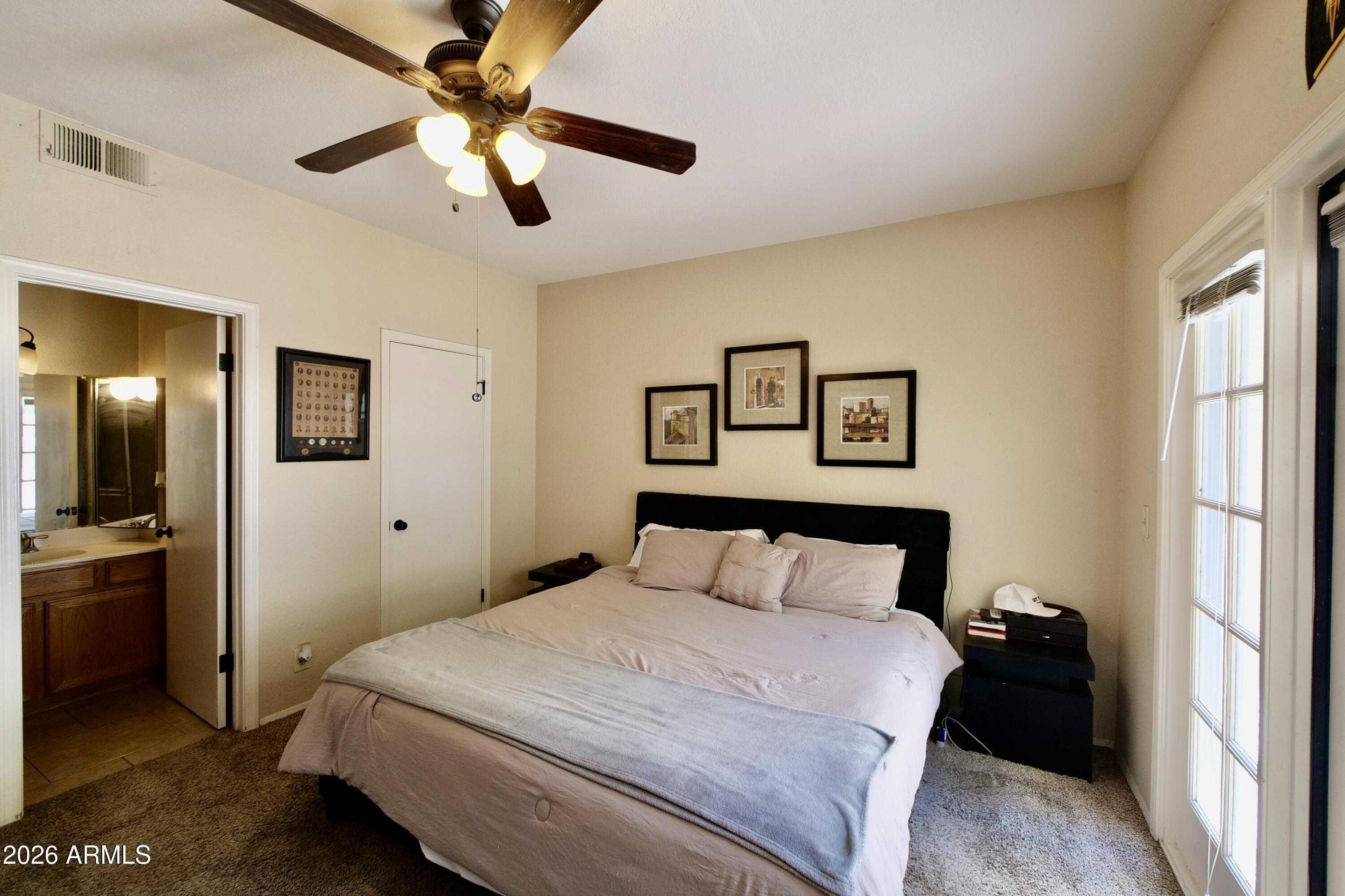 1222 West Baseline Road, Unit 156 Tempe, AZ 85283 - Photo 16 of 27 a bedroom with a bed and a chandelier