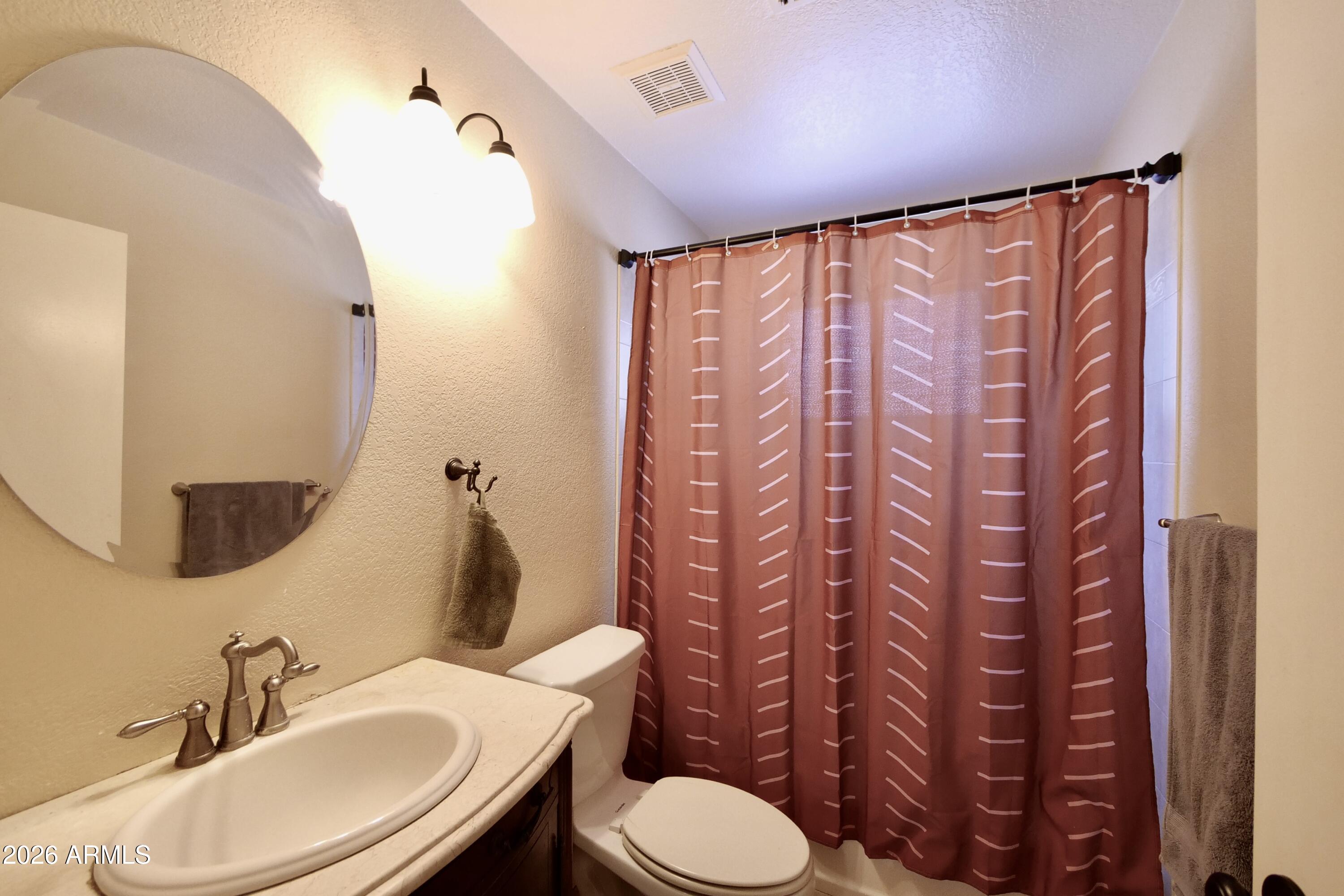 1222 West Baseline Road, Unit 156 Tempe, AZ 85283 - Photo 18 of 27 a bathroom with a sink a toilet and a mirror