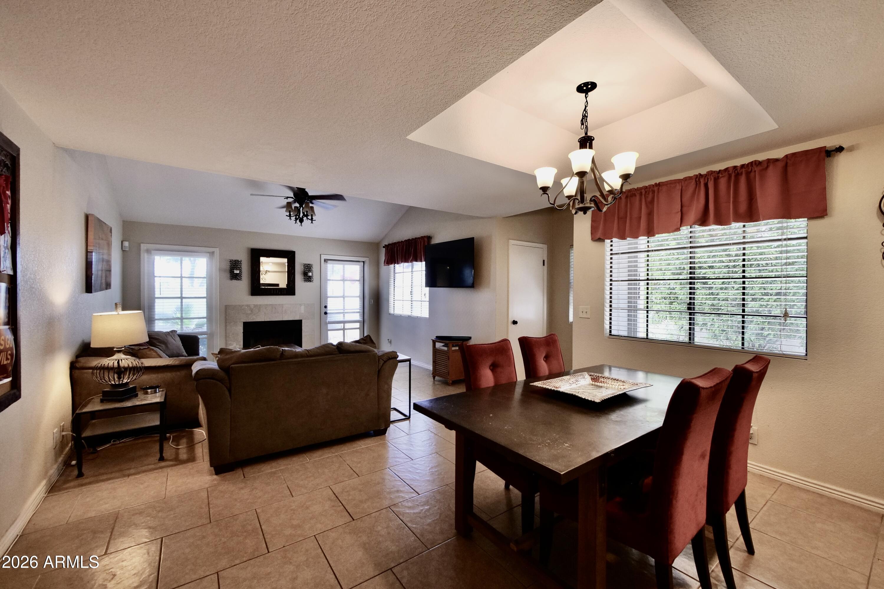1222 West Baseline Road, Unit 156 Tempe, AZ 85283 - Photo 9 of 27 a living room with furniture a chandelier and a flat screen tv