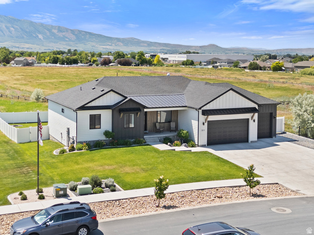3111 South 1250 West Logan, UT 84321 - Photo 47 of 51 Modern farmhouse-style residence with an attached two-car garage, dark trim accents, and a covered entryway