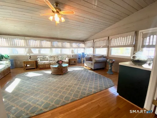 a living room with furniture a flat screen tv and windows