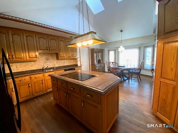 a kitchen with wooden cabinets a sink a stove and a refrigerator