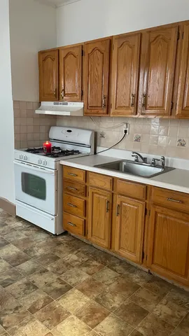 a kitchen with stainless steel appliances granite countertop a sink a stove and cabinets