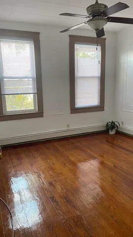 a view of a room with wooden floor and a window