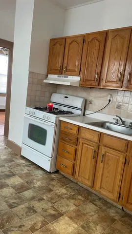 a kitchen with granite countertop a stove a sink and a microwave