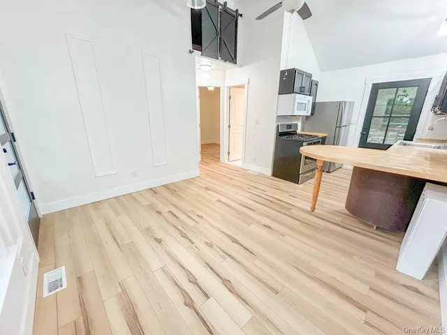 a view of kitchen with wooden floor electronic appliances and window
