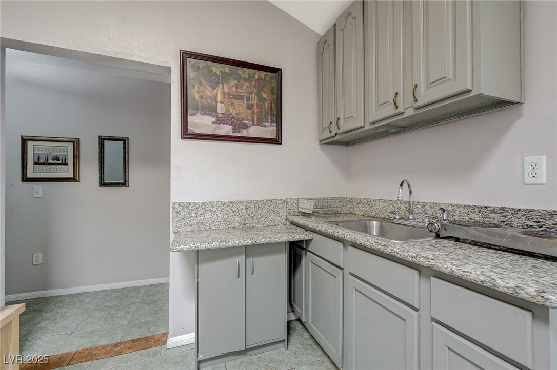 3266 Mountain Spring Road Las Vegas, NV 89146 - Photo 29 of 49 Kitchen with baseboards, a sink, and light tile patterned floors