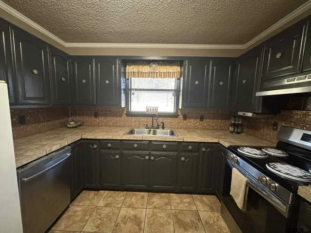 a kitchen with a sink stove top oven and cabinets