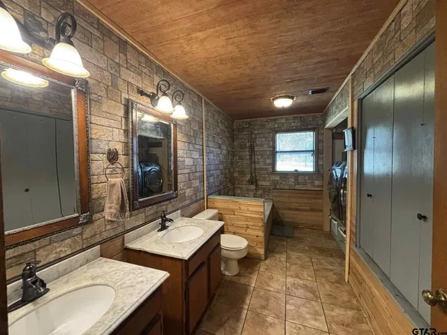 a bathroom with a sink double vanity granite and a mirror