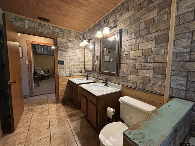 a bathroom with a sink a toilet and mirror