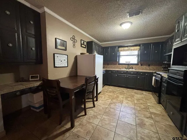 a kitchen with granite countertop a sink a counter top space a stove and cabinets