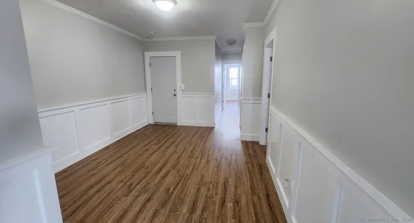 a view of a hallway with wooden floor and staircase