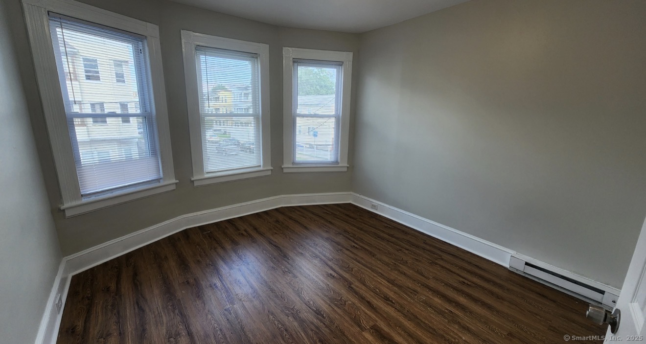 1514 Pembroke Street, Unit 2R Bridgeport, CT 06608 - Photo 6 of 7 a view of an empty room with wooden floor and a window