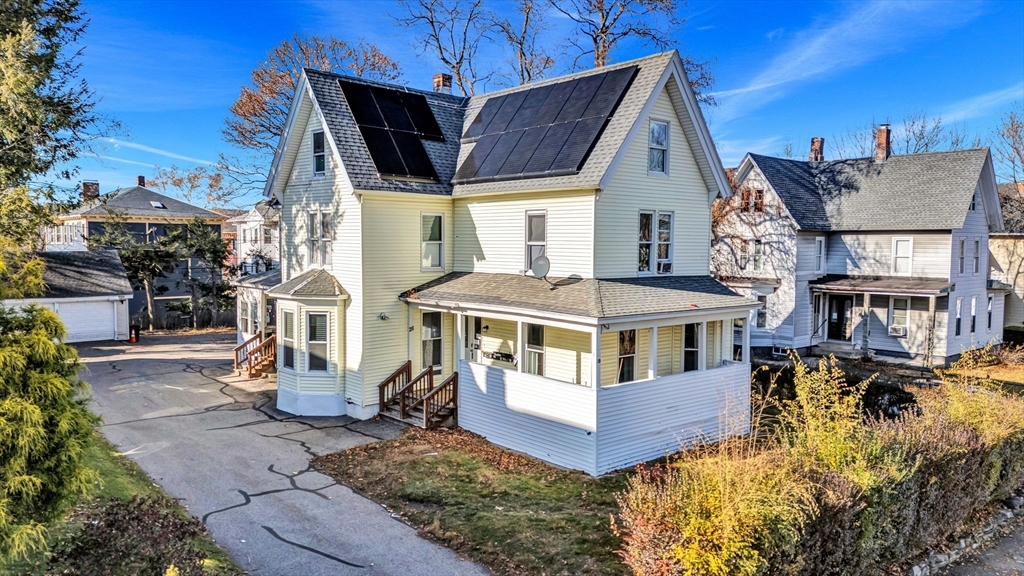 a view of a big house with pool and chairs