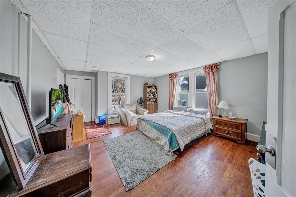 28 Richards Street Worcester, MA 01603 - Photo 21 of 42 a bedroom with a bed and wooden floor