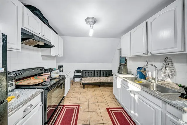 a kitchen with granite countertop a stove and a sink