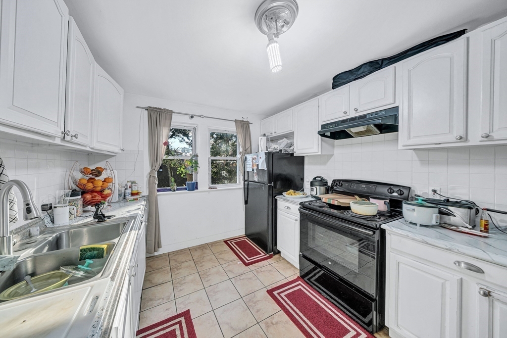 28 Richards Street Worcester, MA 01603 - Photo 34 of 42 a kitchen with granite countertop a stove and a sink