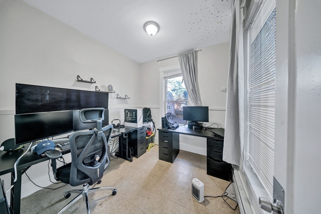 28 Richards Street Worcester, MA 01603 - Photo 10 of 42 a view of a workspace with furniture and a flat screen tv