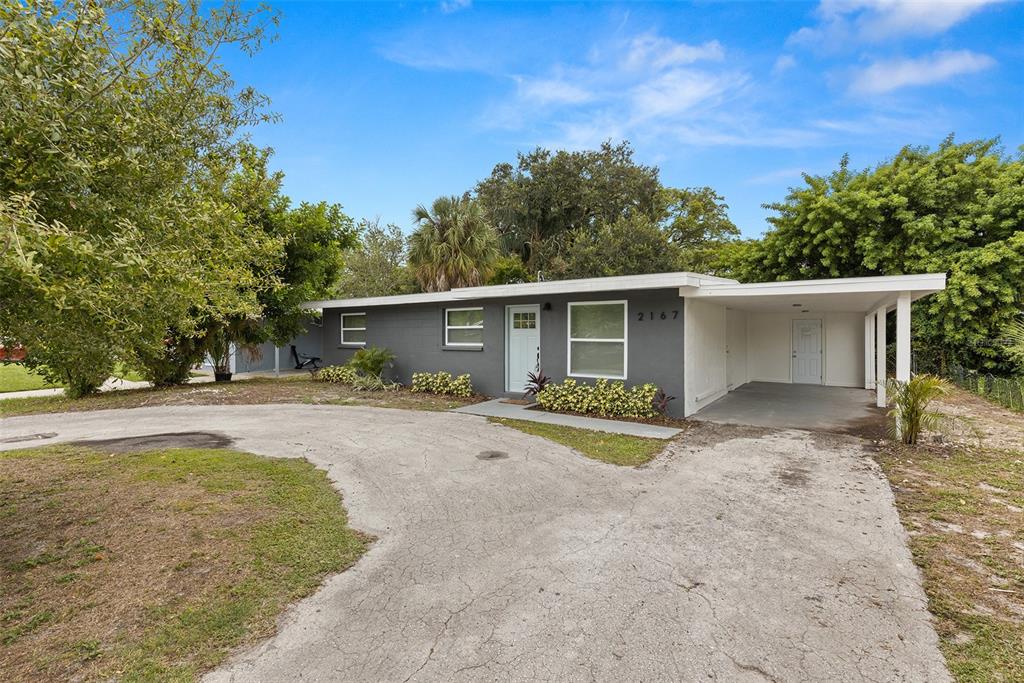 2167 Barcelona Drive Clearwater, FL 33764 - Photo 1 of 28 front view of house with a yard and trees in the background