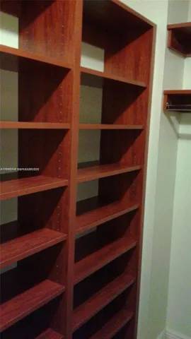 a view of walk in closet with empty racks