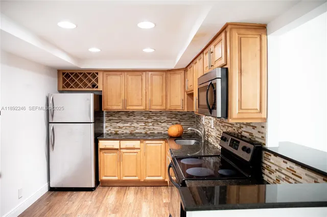a kitchen with a refrigerator and a stove top oven