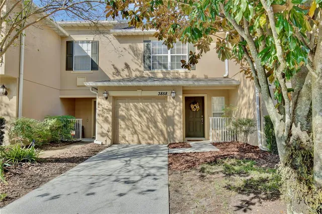front view of a brick house with a large window and potted plants