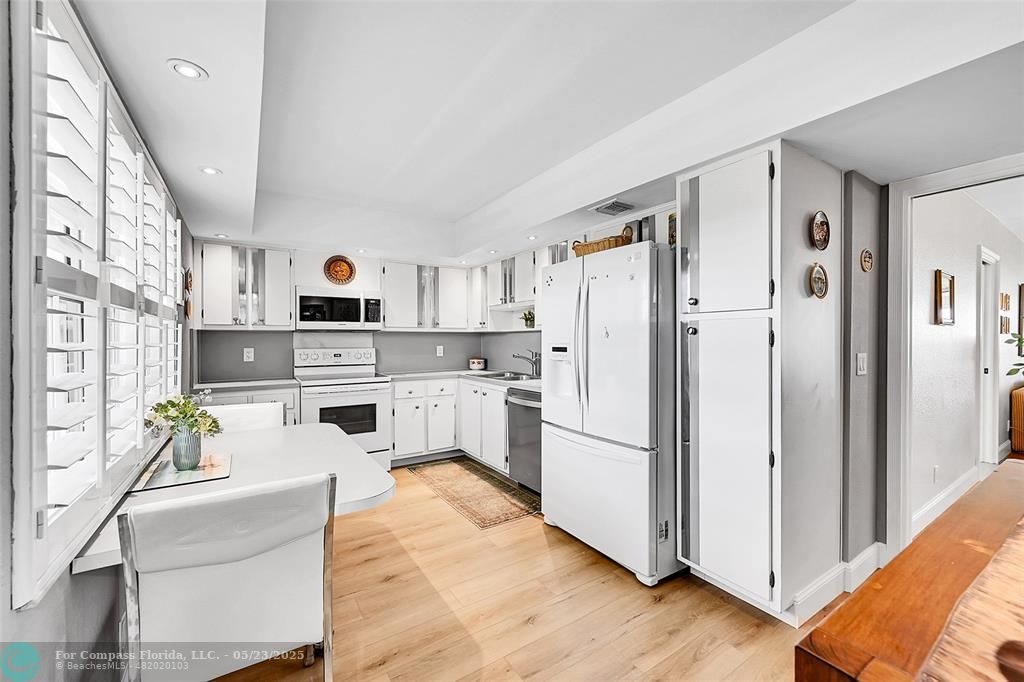 4020 West Palm Aire Drive, Unit 503 Pompano Beach, FL 33069 - Photo 12 of 53 a kitchen with stainless steel appliances a refrigerator sink and white cabinets