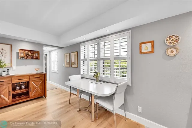 a dining room with wooden floor and large window