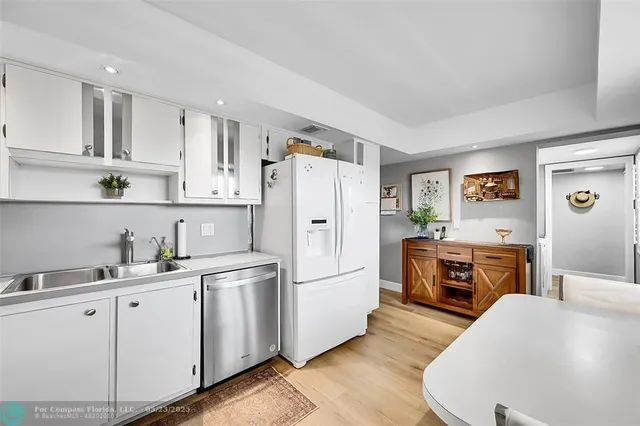 a kitchen with cabinets a sink and white appliances