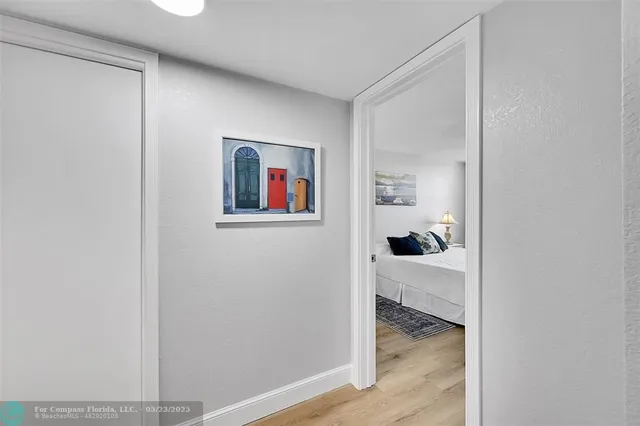 a view of a hallway with wooden floor and closet