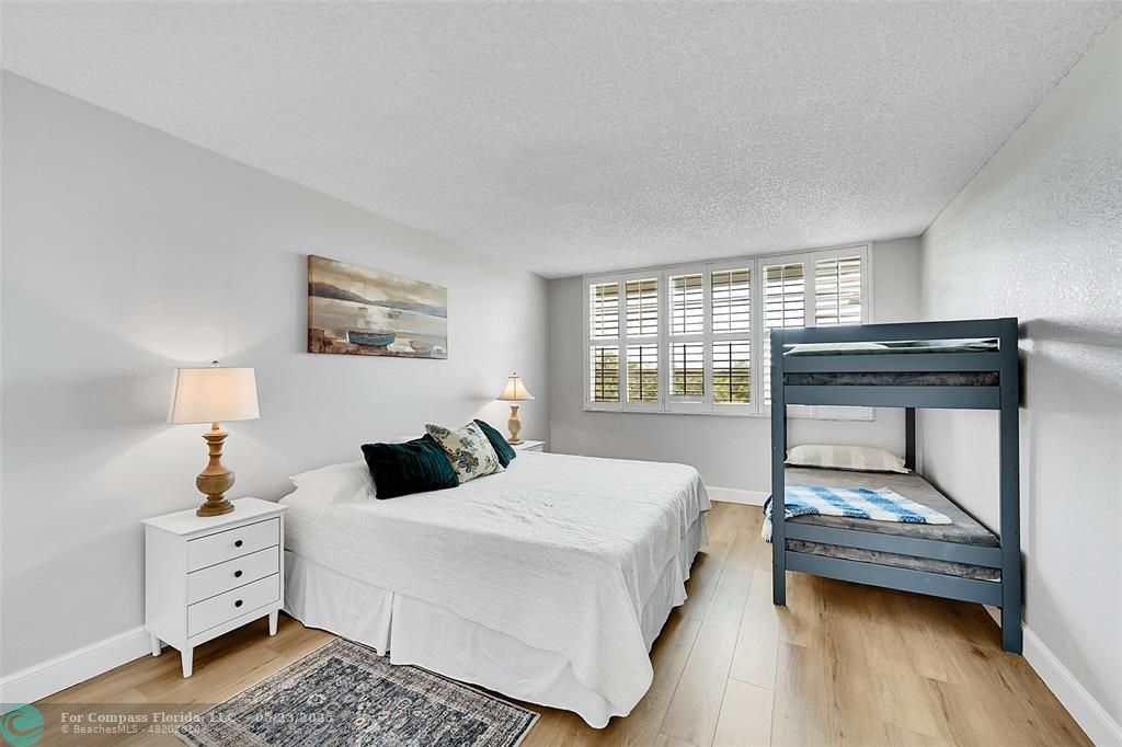 4020 West Palm Aire Drive, Unit 503 Pompano Beach, FL 33069 - Photo 17 of 53 a bedroom with a bed and wooden floor