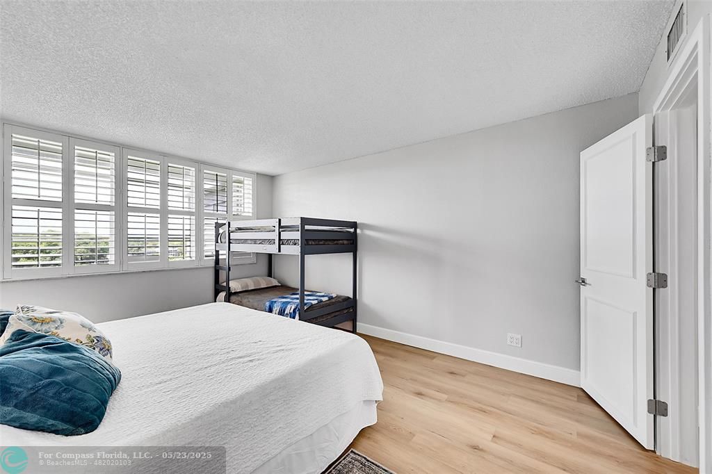 4020 West Palm Aire Drive, Unit 503 Pompano Beach, FL 33069 - Photo 18 of 53 a bedroom with a bed and wooden floor