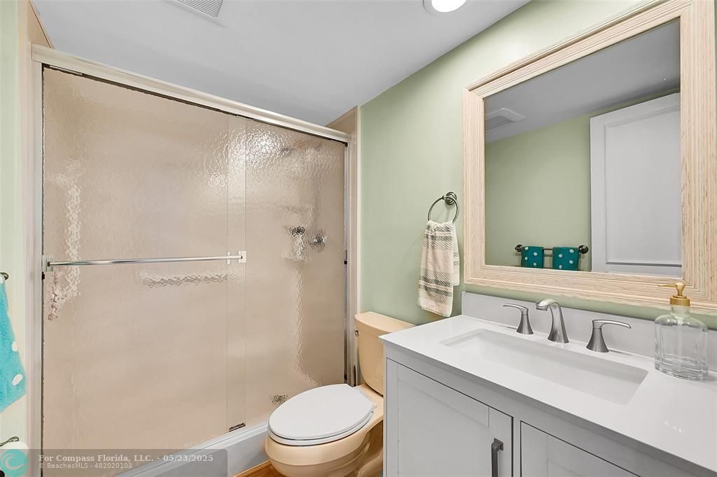4020 West Palm Aire Drive, Unit 503 Pompano Beach, FL 33069 - Photo 26 of 53 a bathroom with a sink a mirror a toilet and shower