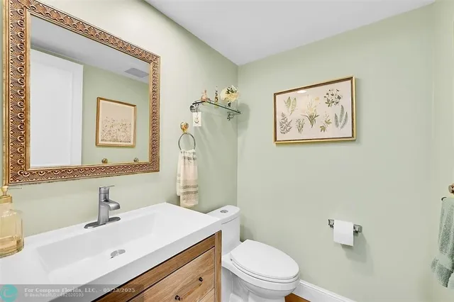 a bathroom with a sink mirror vanity and toilet