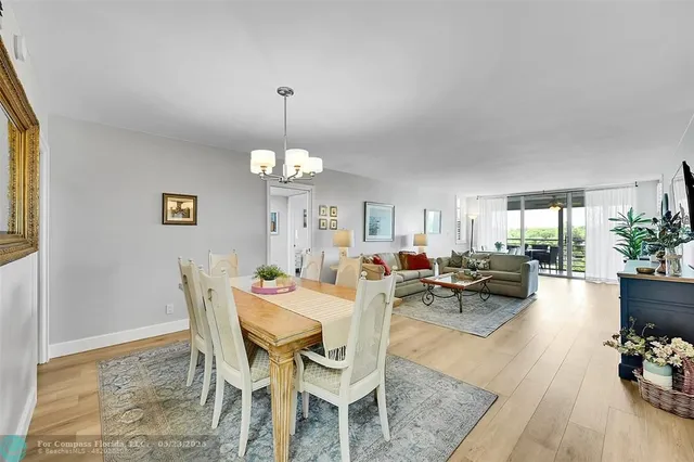 a view of a dining room and livingroom with furniture wooden floor and a chandelier