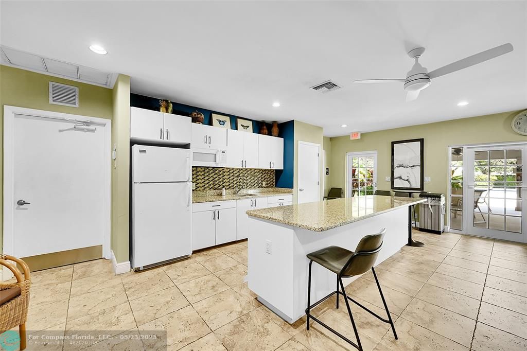 4020 West Palm Aire Drive, Unit 503 Pompano Beach, FL 33069 - Photo 38 of 53 a kitchen with stainless steel appliances kitchen island granite countertop a refrigerator and cabinets