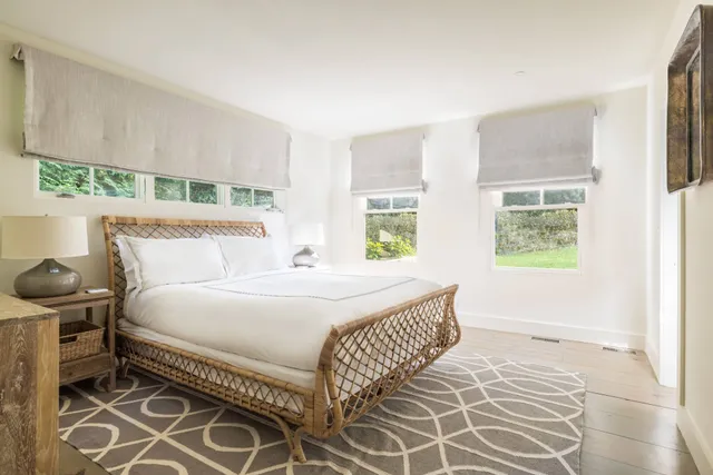 a bedroom with a bed and windows