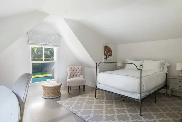 a bedroom with a bed and a painting on the wall