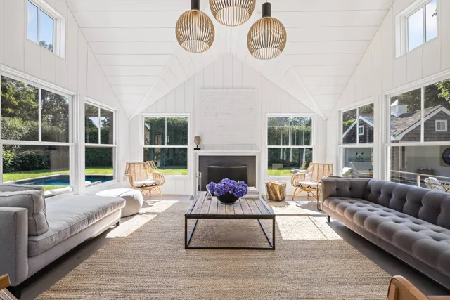 a living room with furniture wooden floor and large window