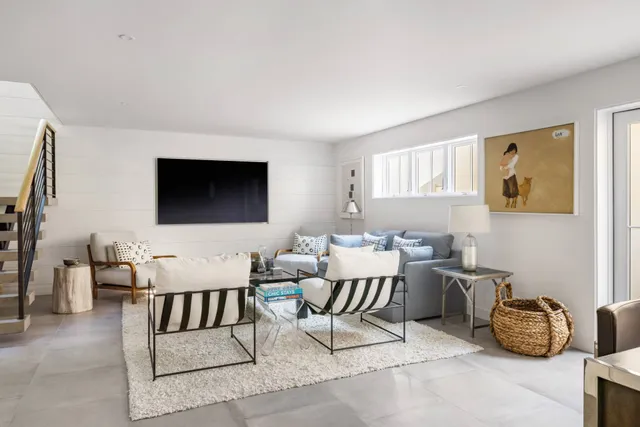 a living room with furniture a flat screen tv and kitchen view