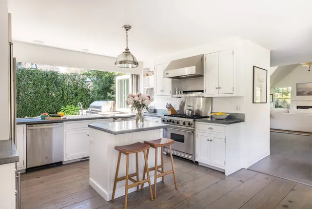 a kitchen with stainless steel appliances granite countertop a stove and white cabinets