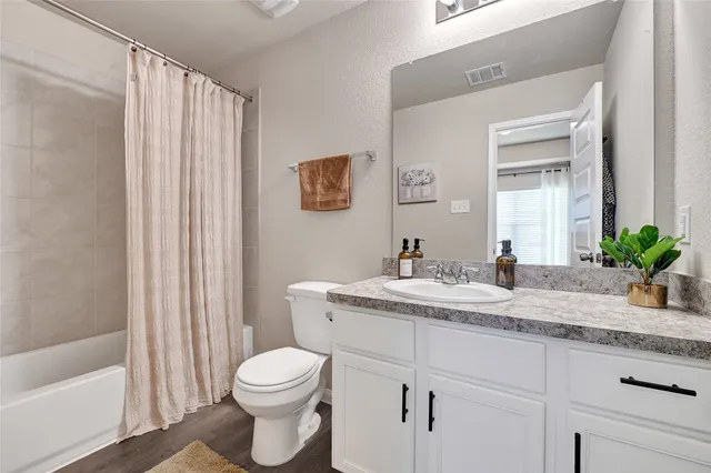 a bathroom with a granite countertop sink mirror vanity and toilet