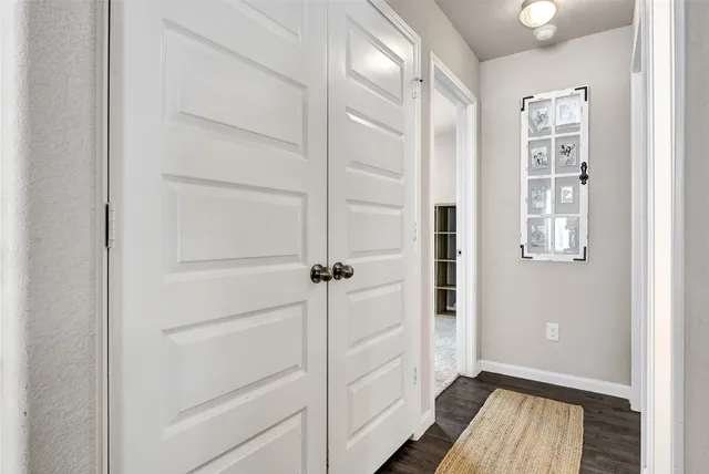 a view of a hallway with wooden floor and closet