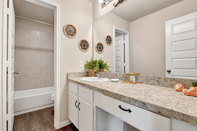 a bathroom with a granite countertop sink and a mirror