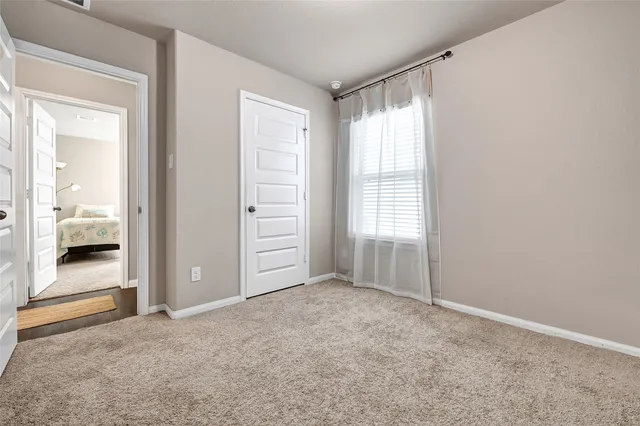 an empty room with windows and closet