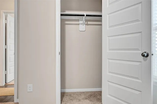a view of walk in closet with empty racks