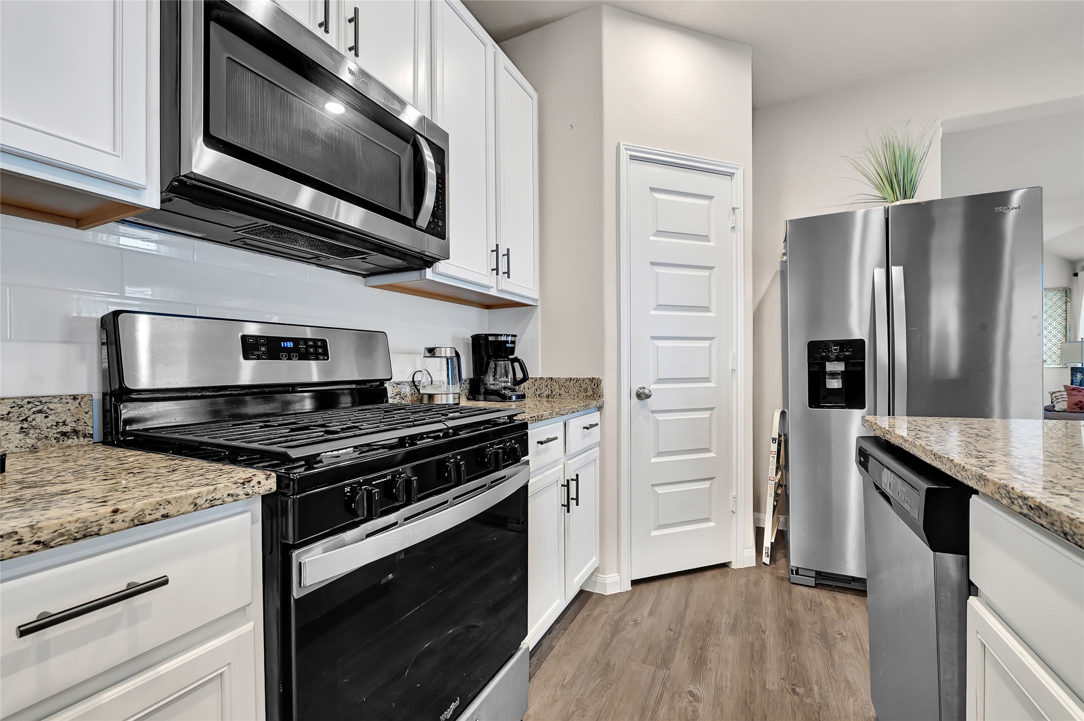 1329 Mount Blanc Path Conroe, TX 77301 - Photo 9 of 23 a kitchen with stainless steel appliances granite countertop a stove microwave and refrigerator